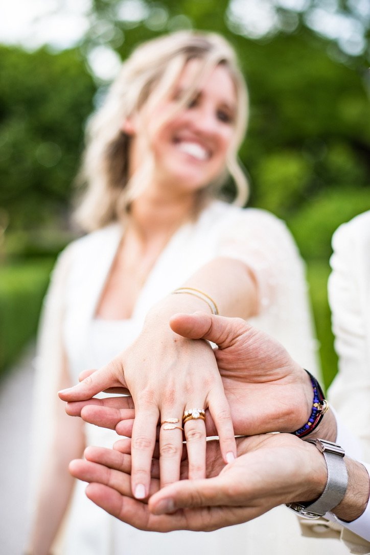 Les alliances au creux des mains, une mariée qui rit