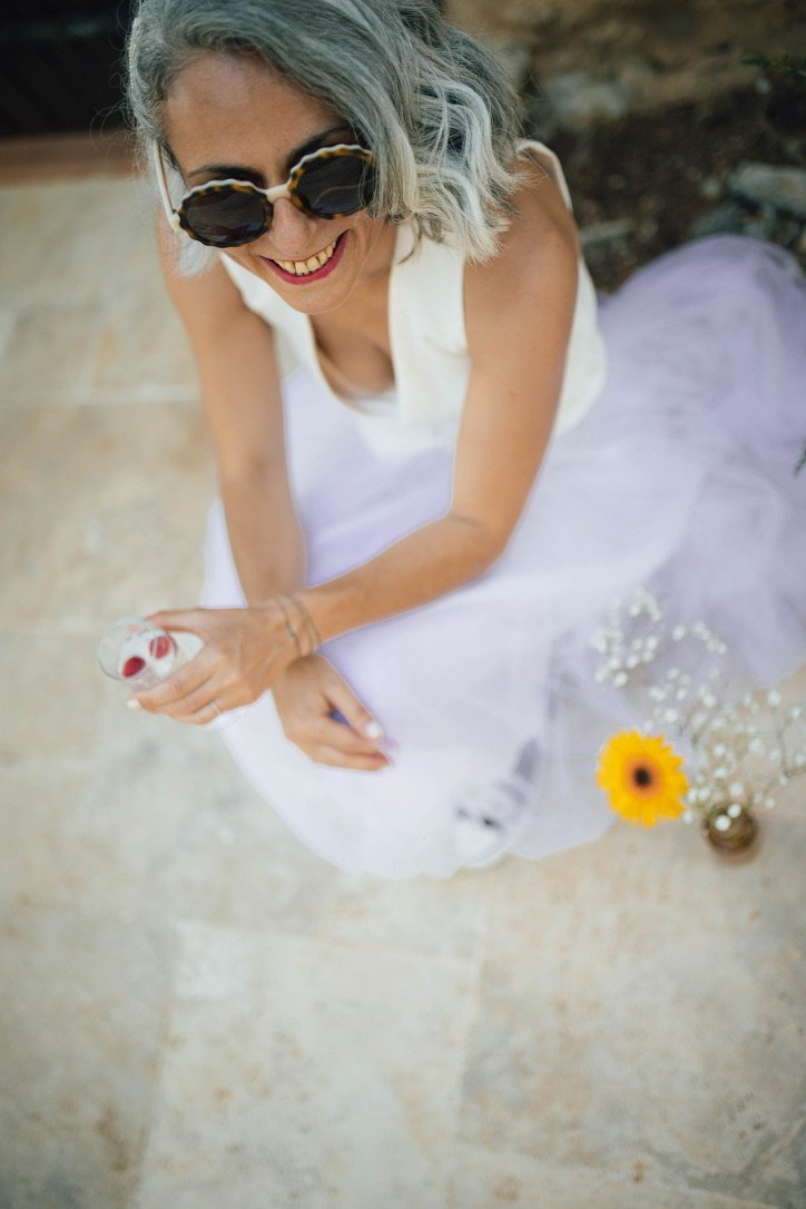 Lunettes rondes et jupe lilas, la joie tranquille d’un après-midi de fête.