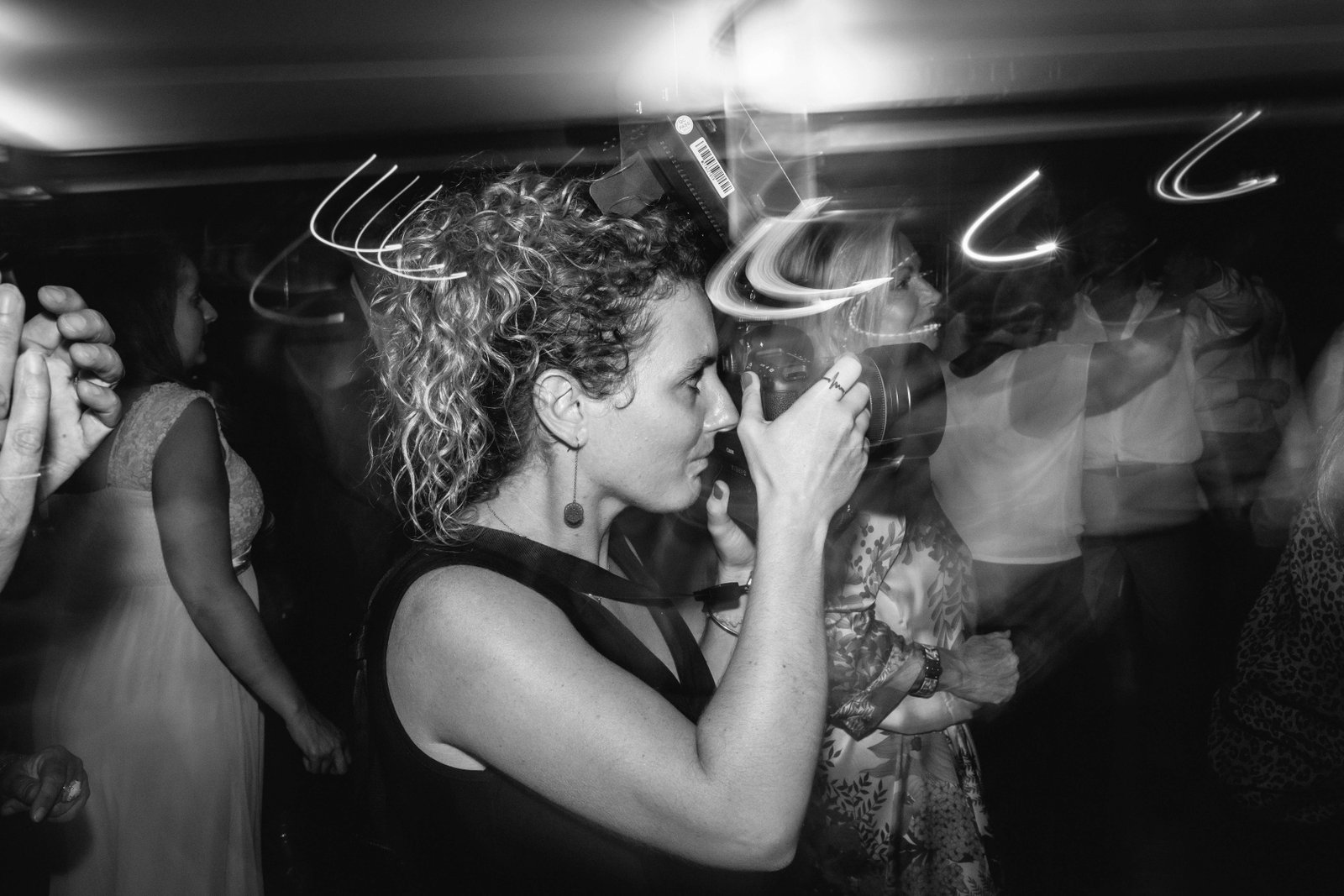 Myriam Ravalec en plein travail, l'œil dans le viseur, lors d'une soirée de mariage